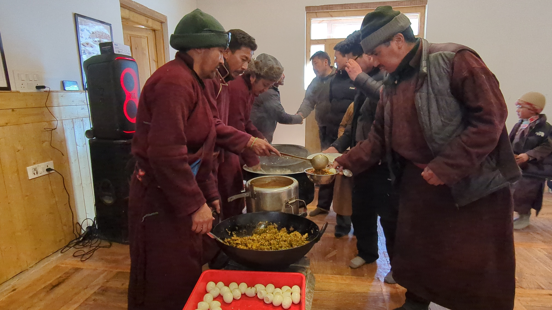 Villagers ladling steaming curry for a shared meal